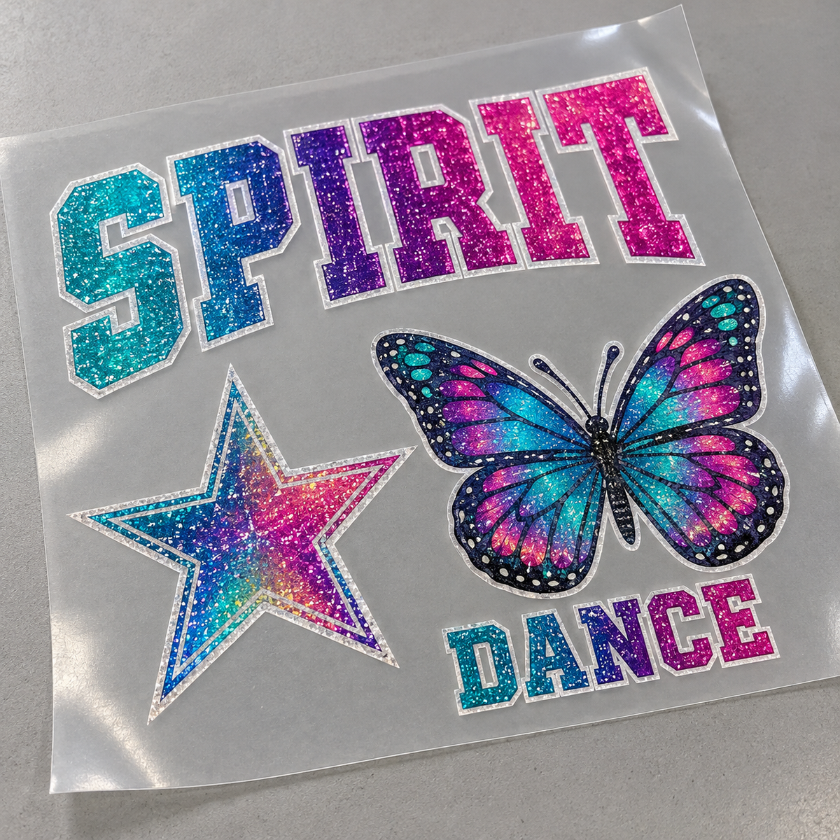 Illustrative mockup: full-color Glitter DTF designs on carrier film before pressing. Actual appearance varies.